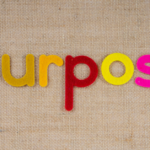 Felt letters spelling the word purpose on an hessian background